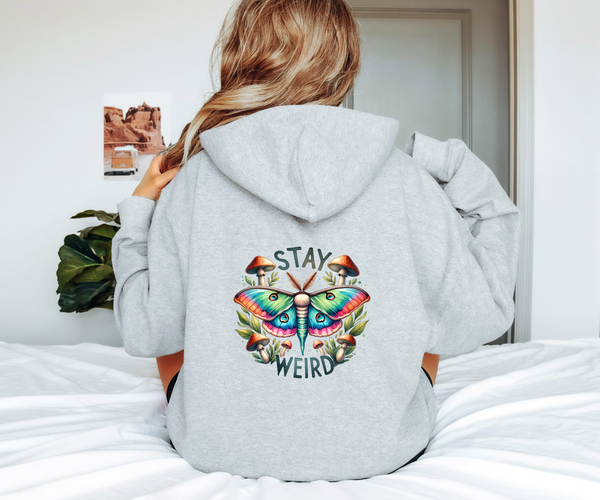 Person wearing a gray hoodie with a colorful butterfly design and 'Stay Weird' text on the back.