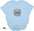 Light blue t-shirt with a colorful butterfly graphic and 'Stay Weird' text on a white background.