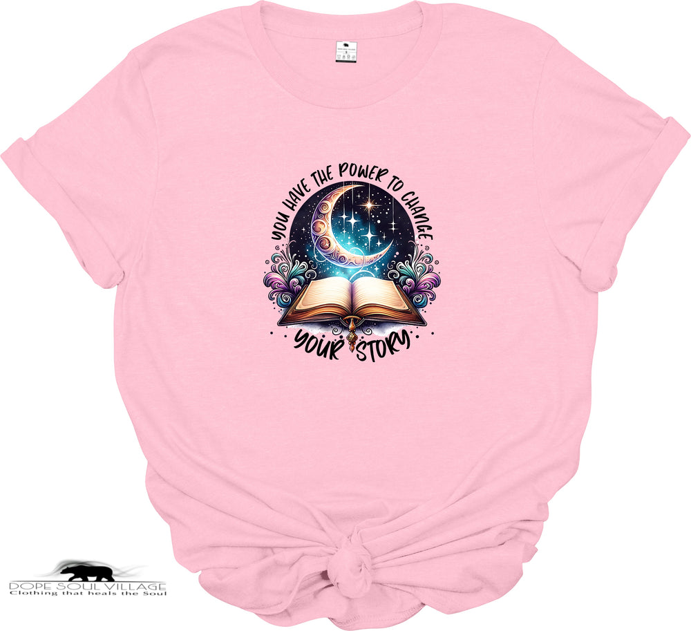 Pink t-shirt with a graphic design of an open book, crescent moon, and stars on a white background.