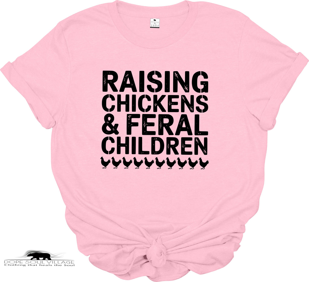 Pink t-shirt with black text 'RAISING CHICKENS & FERAL CHILDREN' on a white background
