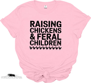 Pink t-shirt with black text 'RAISING CHICKENS & FERAL CHILDREN' on a white background
