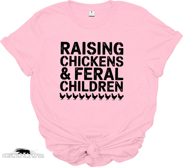 Pink t-shirt with black text 'RAISING CHICKENS & FERAL CHILDREN' on a white background
