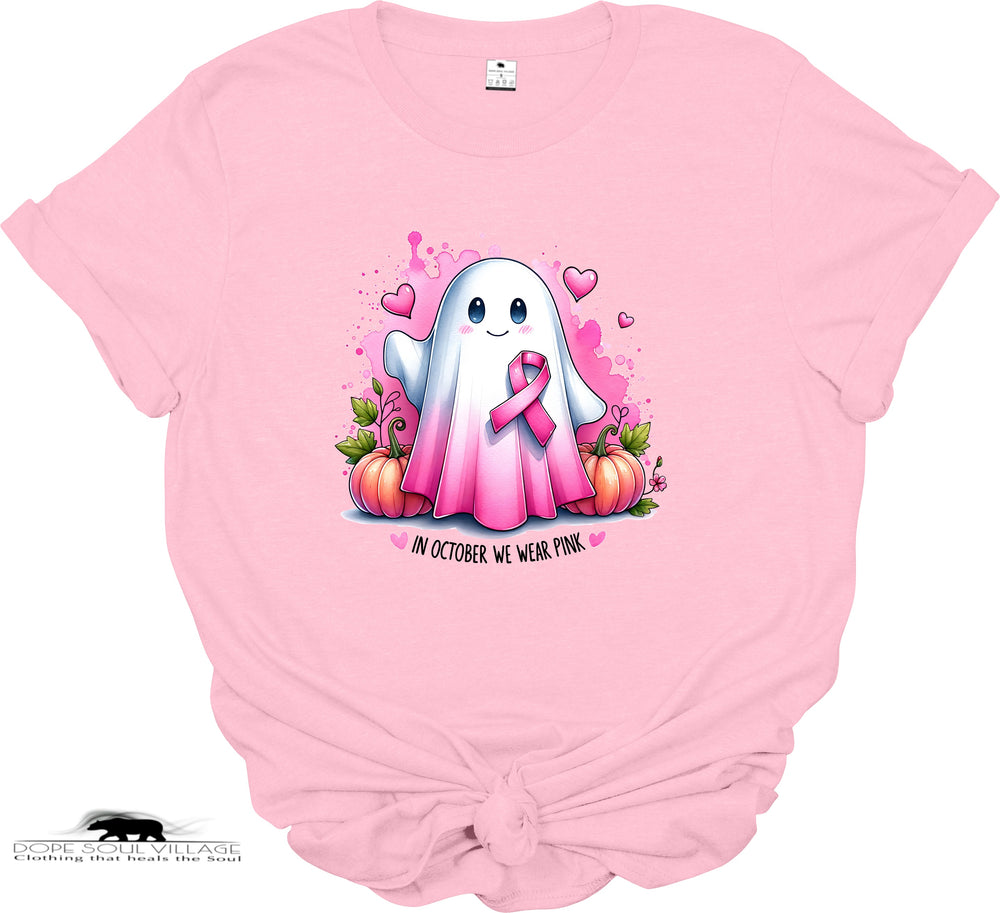 Pink t-shirt with a ghost character wearing a pink ribbon and pumpkins on a white background.