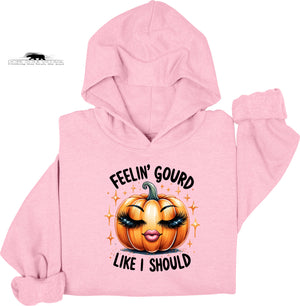 Pink hoodie with a pumpkin graphic and text on a white background