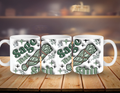 Three white mugs with green text and designs on a wooden surface.