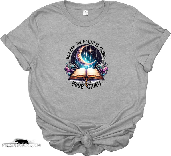 Gray t-shirt with a graphic design of an open book, crescent moon, and flowers on a white background.