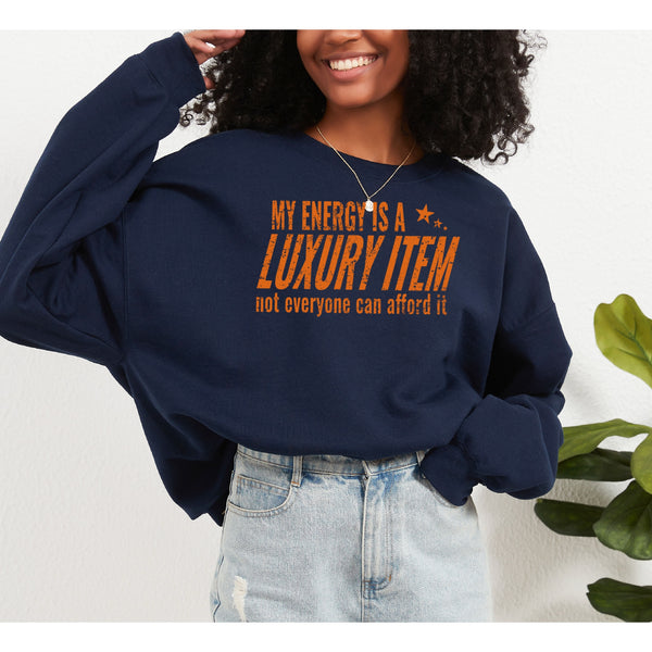Person wearing a navy blue sweatshirt with orange text, standing against a white background with a plant.