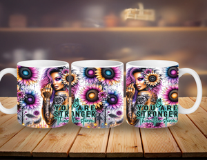 Three mugs with floral designs and motivational text on a wooden surface.