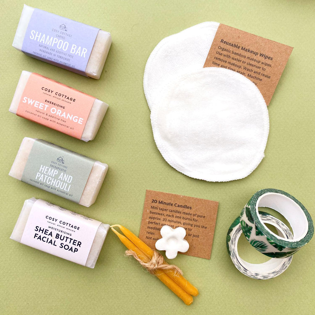 Examples of plastic-free cracker gifts including travel size soap and shampoo bars, reusable makeup wipes, mini beeswax candles and decorative washi tape